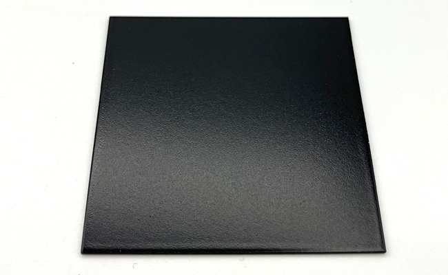 Glossy black square tile with a subtle horizontal gradient on a white surface.